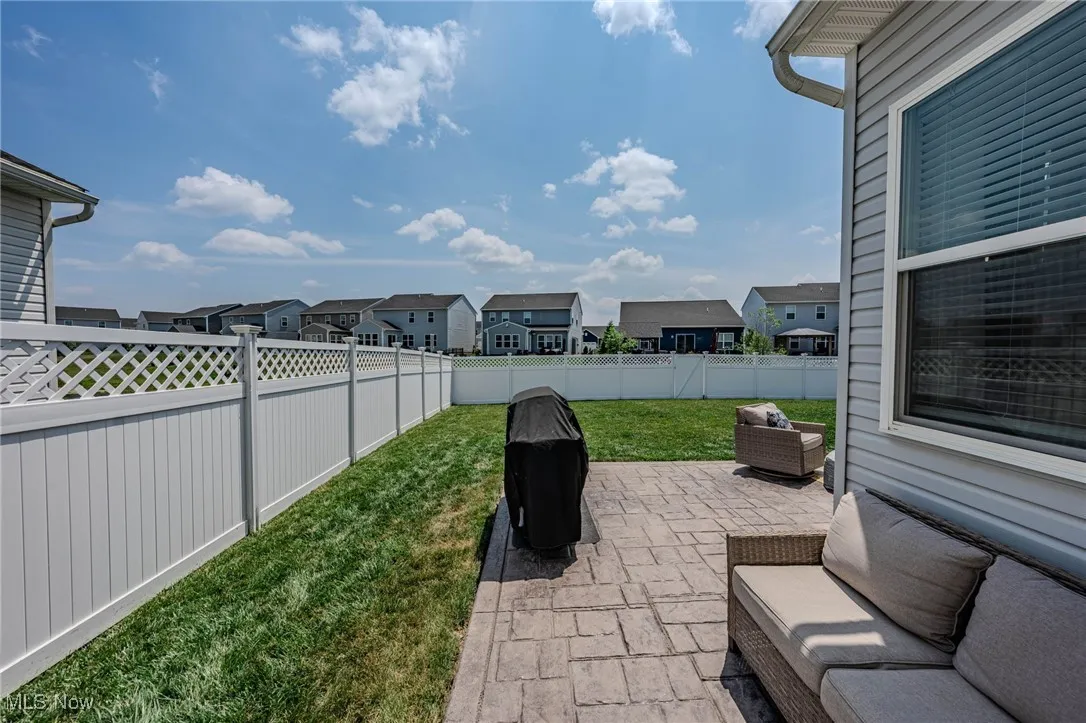 Fenced backyard featuring a patio area and a residential view