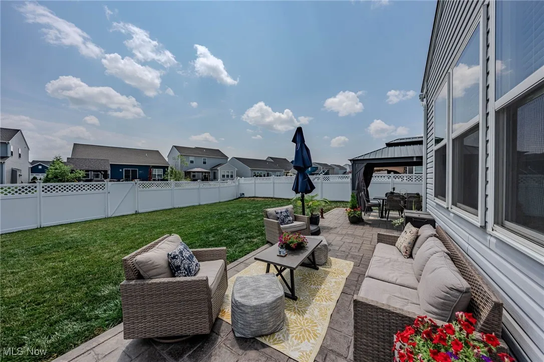 Fenced backyard featuring outdoor lounge area, a residential view, a gazebo, and a patio