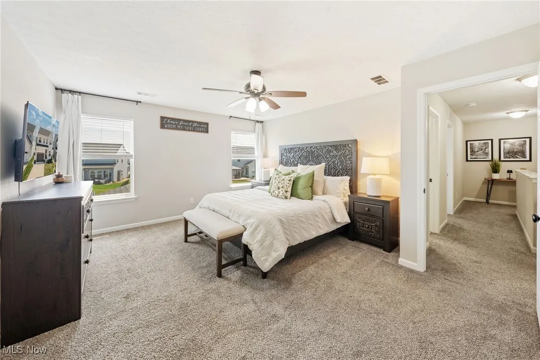 Carpeted bedroom featuring baseboards and a ceiling fan