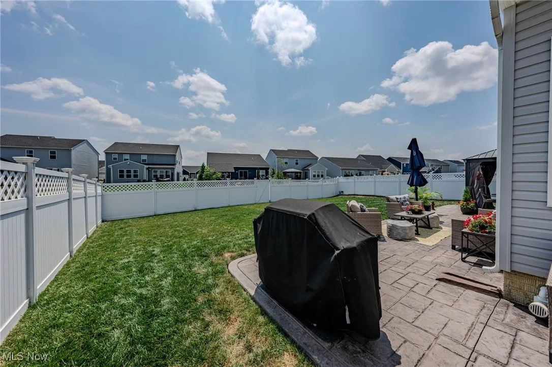 Fenced backyard featuring a residential view and a patio