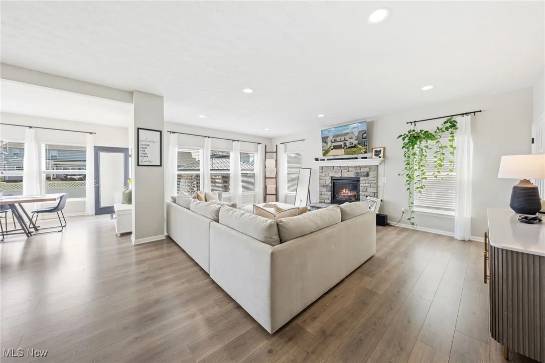 Living room with a fireplace, wood finished floors, plenty of natural light, and recessed lighting