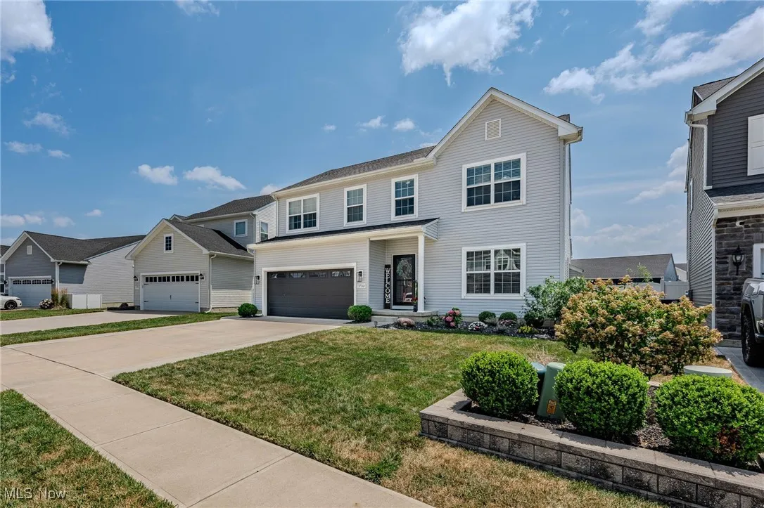 View of front of house with a front lawn, driveway, and an attached garage