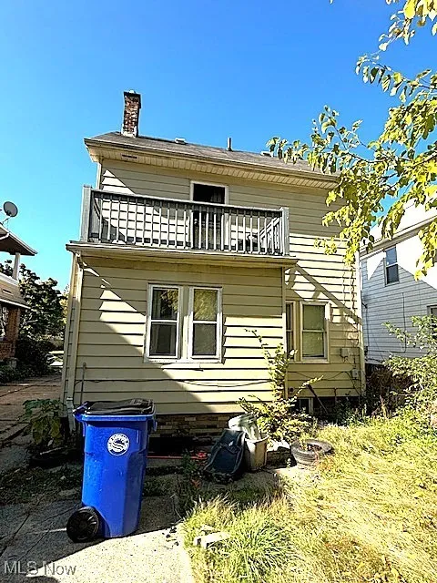 Back of property featuring a balcony and a chimney