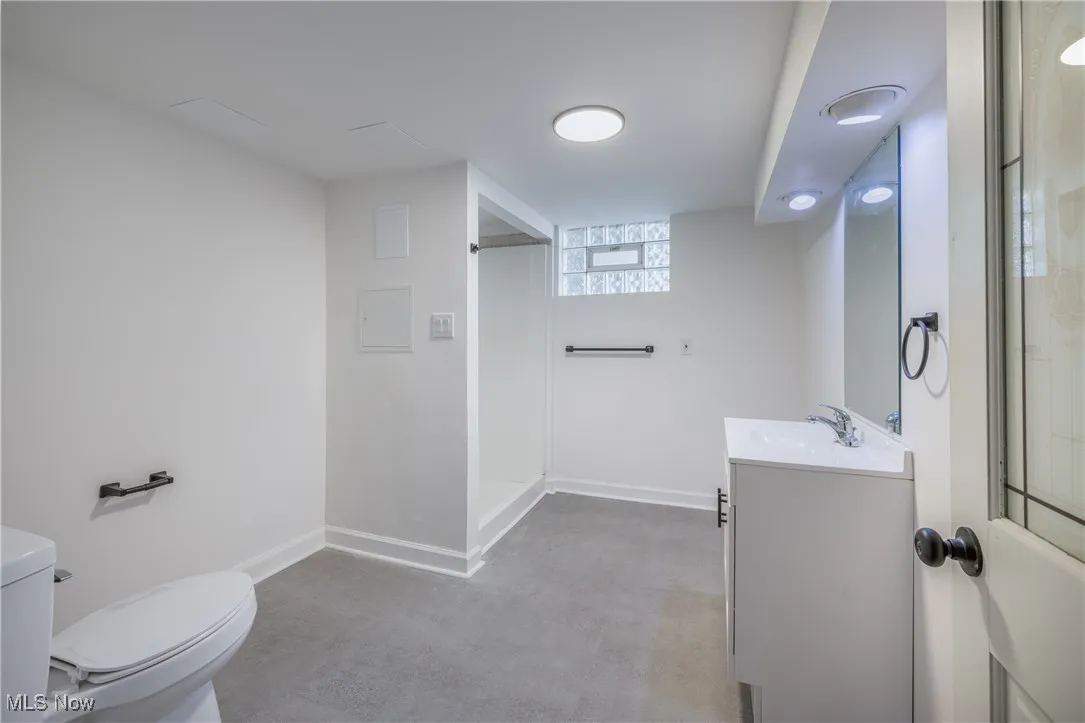 Full bathroom featuring vanity, finished concrete flooring, and a shower