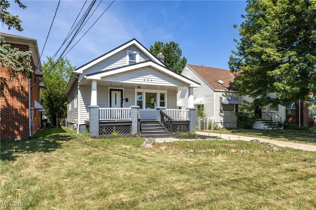 View of front facade featuring covered porch and a front yard