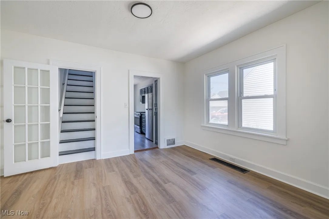 Unfurnished room with wood finished floors and stairway