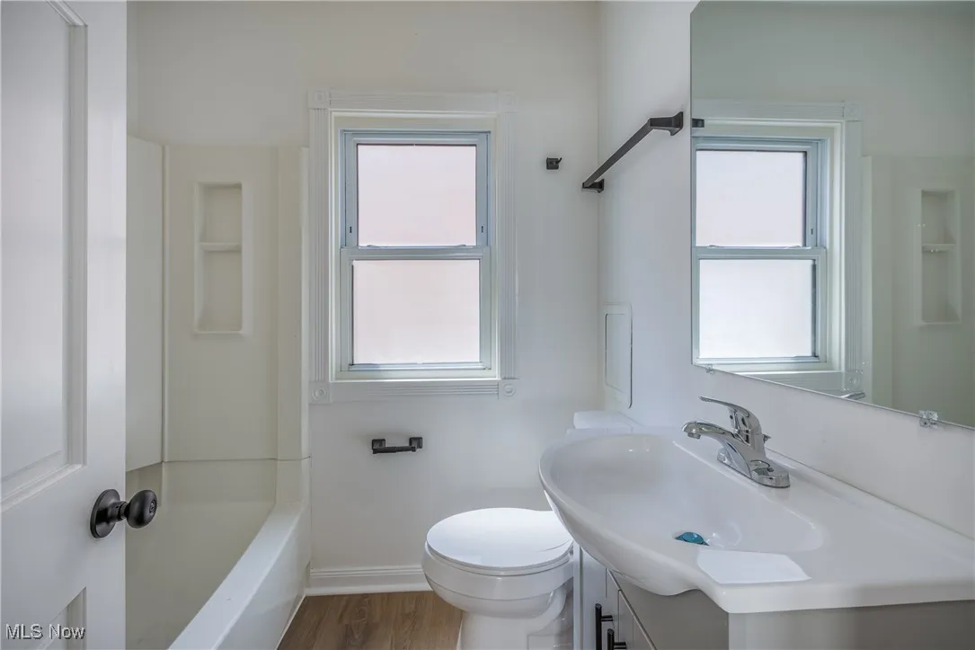 Full bath with vanity and wood finished floors