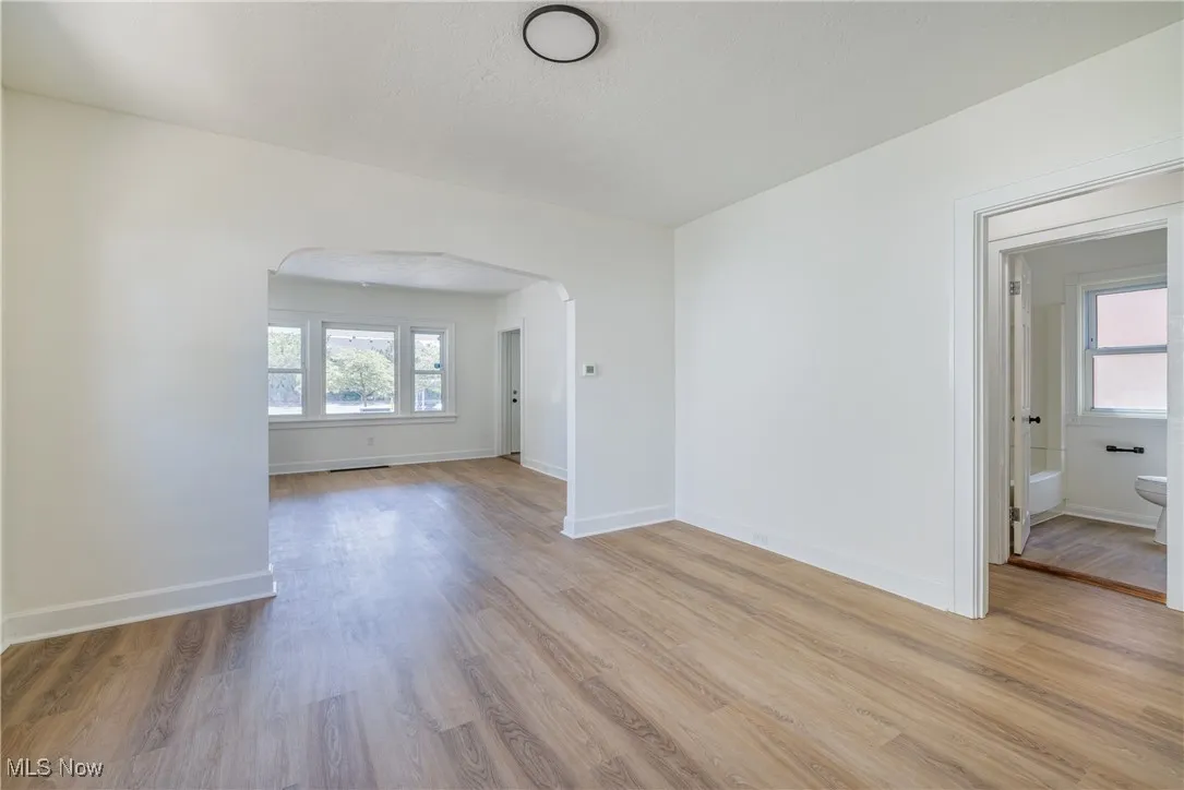Spare room with light wood-type flooring and arched walkways
