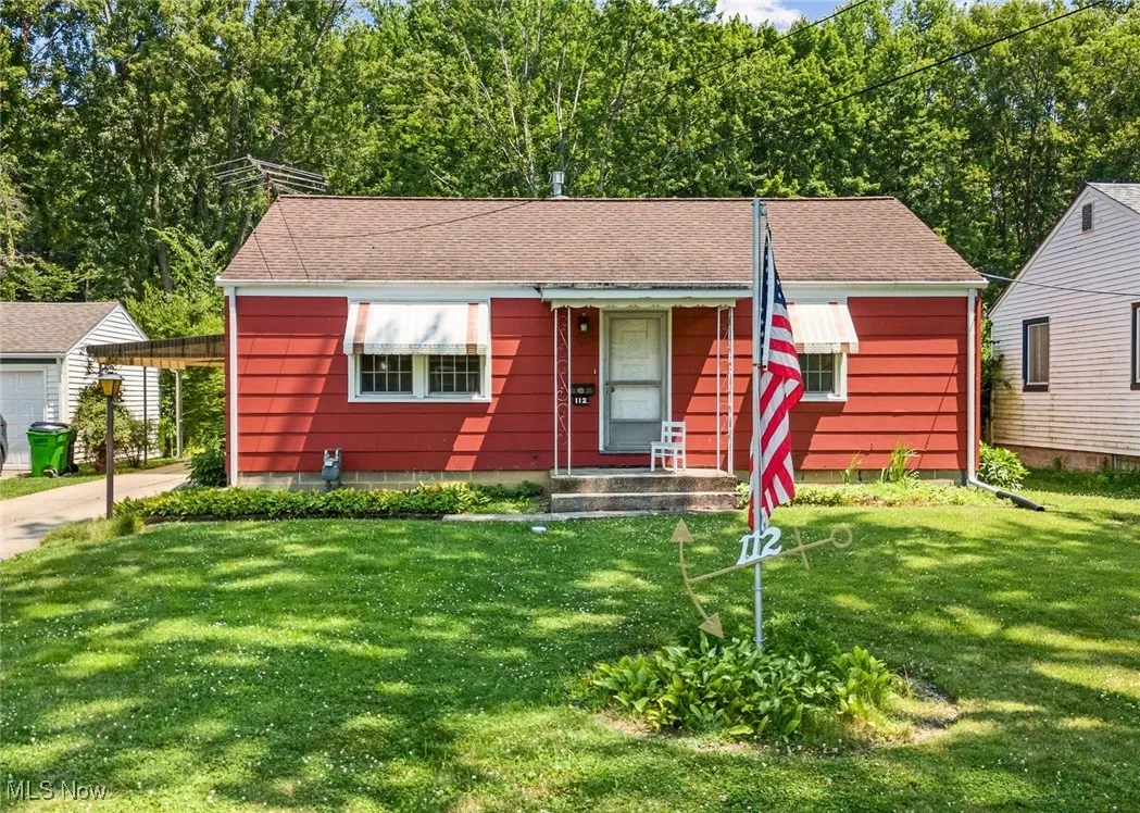 Bungalow-style home with a front lawn, a shingled roof, and a porch