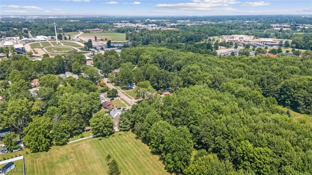 Aerial view of property and surrounding area with a forest