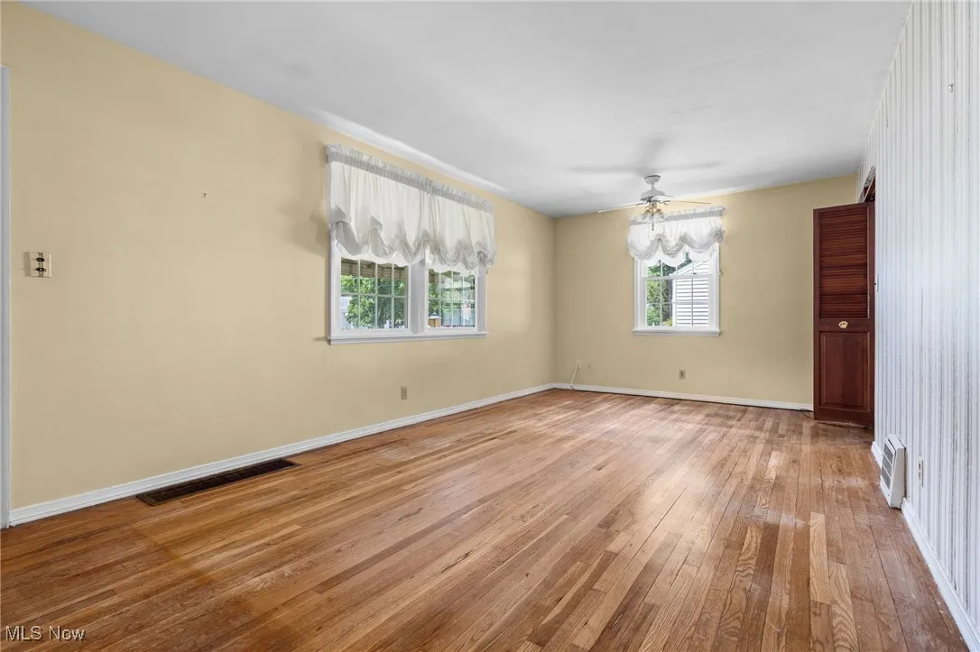 Empty room with light wood-type flooring and a ceiling fan