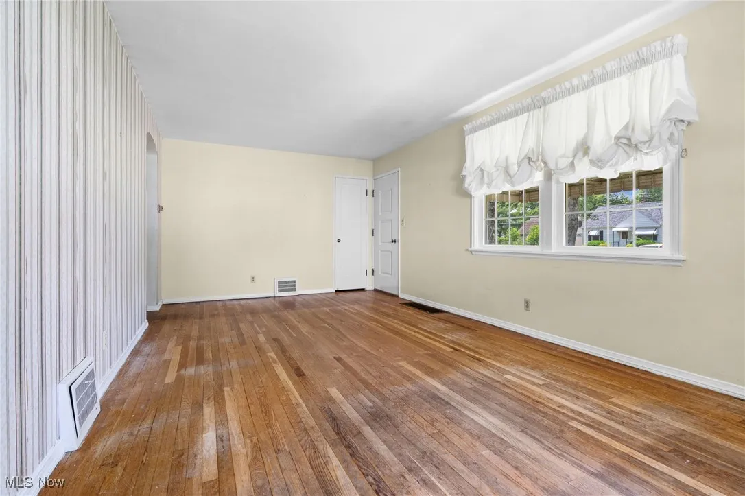 Spare room with hardwood / wood-style flooring and baseboards