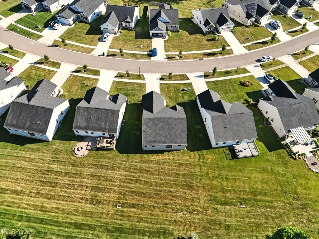 Aerial view of property and surrounding area featuring nearby suburban area