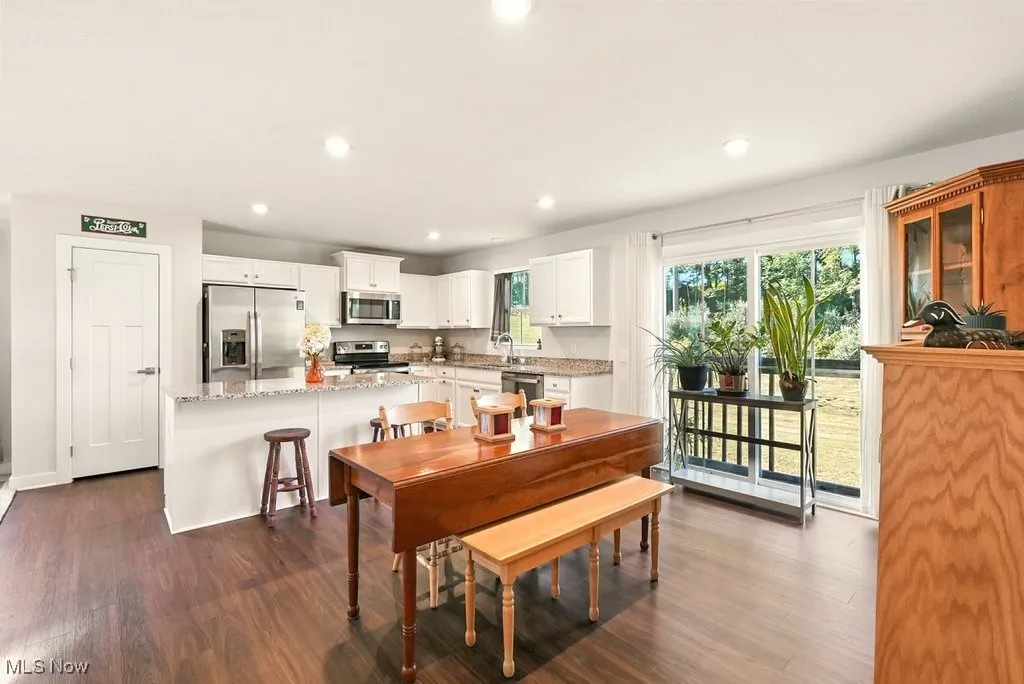 Dining area featuring dark wood-style flooring and recessed lighting