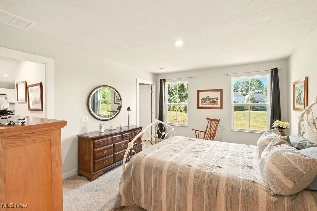 Bedroom with light colored carpet and recessed lighting