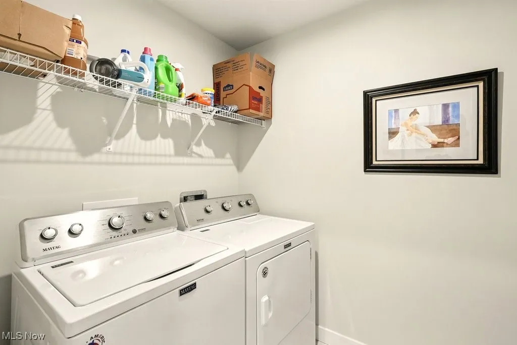 Laundry area featuring washing machine and dryer and baseboards