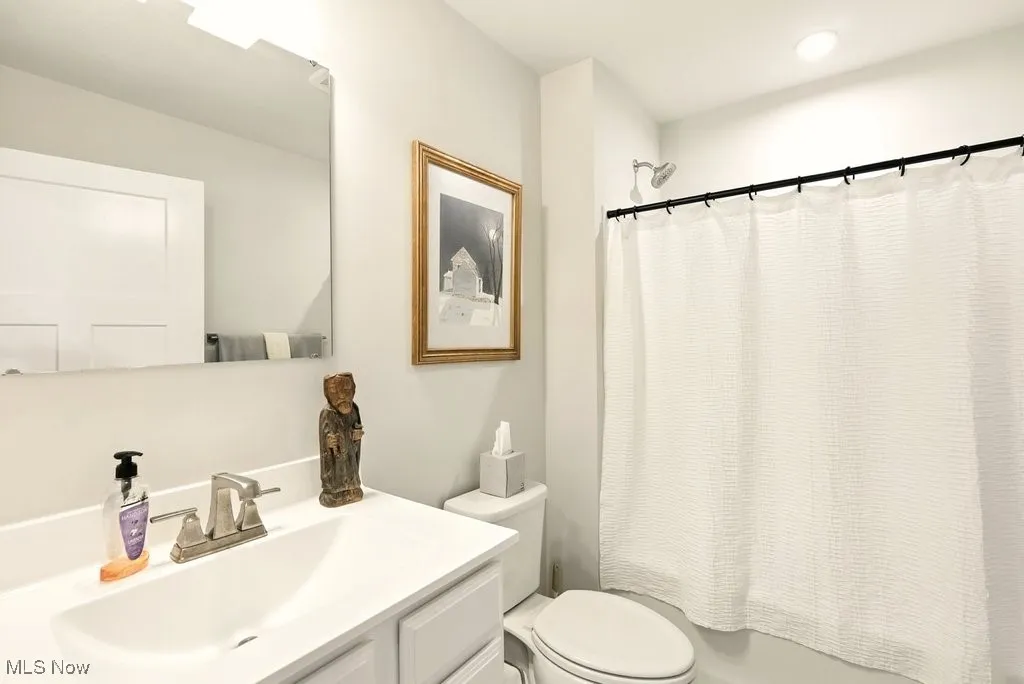 Full bath featuring vanity, shower / bath combo with shower curtain, and recessed lighting