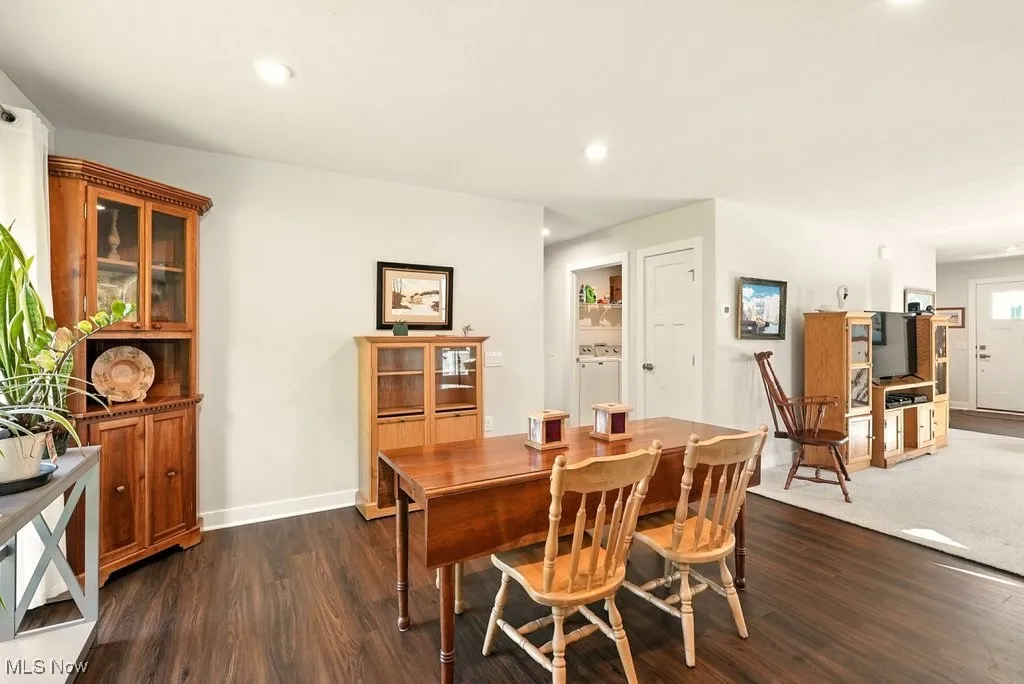 Dining area featuring dark wood finished floors, recessed lighting, and washer and clothes dryer