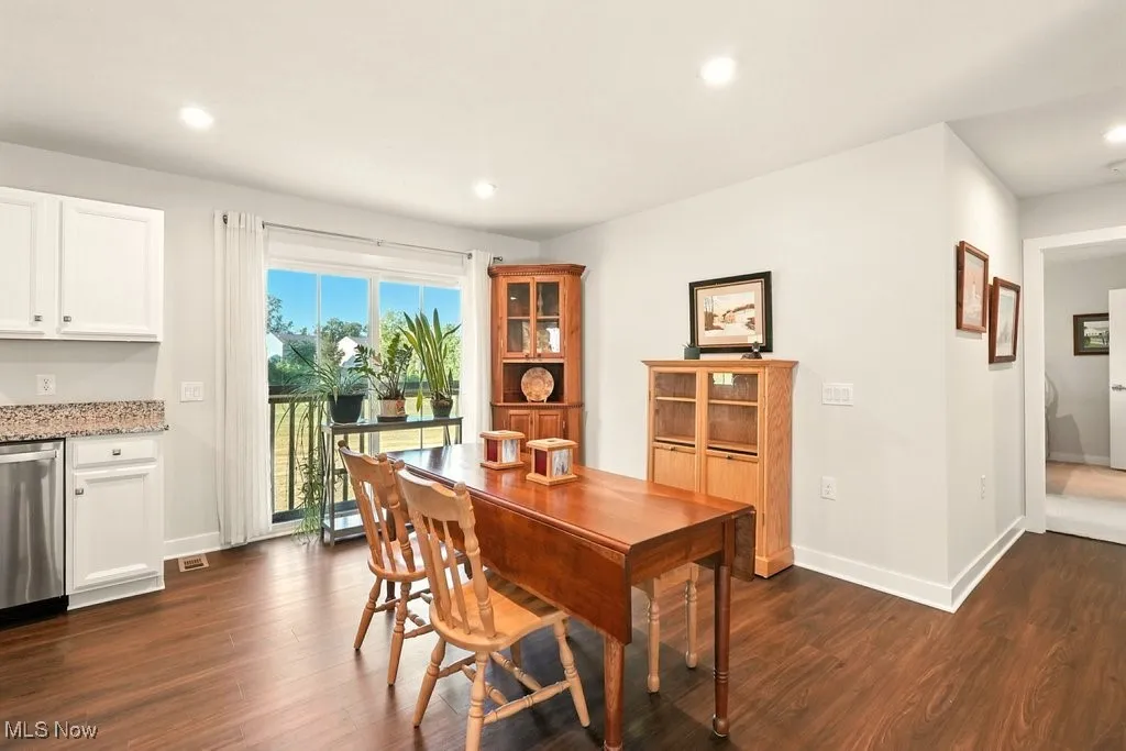 Dining area featuring dark wood-style flooring, recessed lighting, and a desk