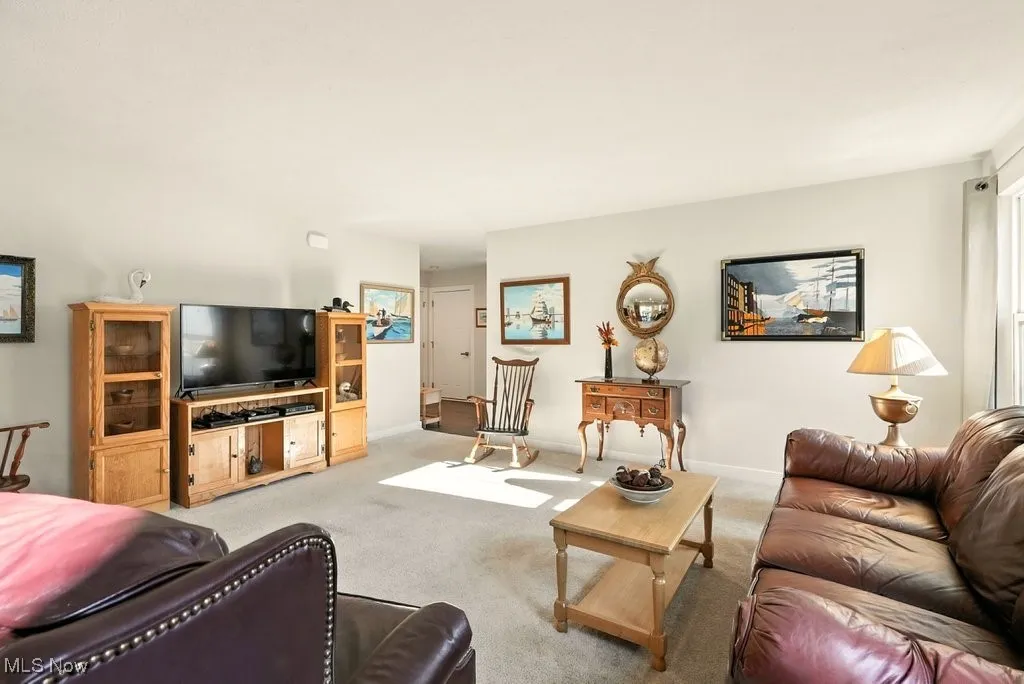 Carpeted living area featuring baseboards