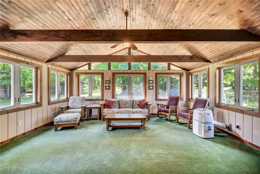 Living area with wood ceiling, carpet, and ceiling fan