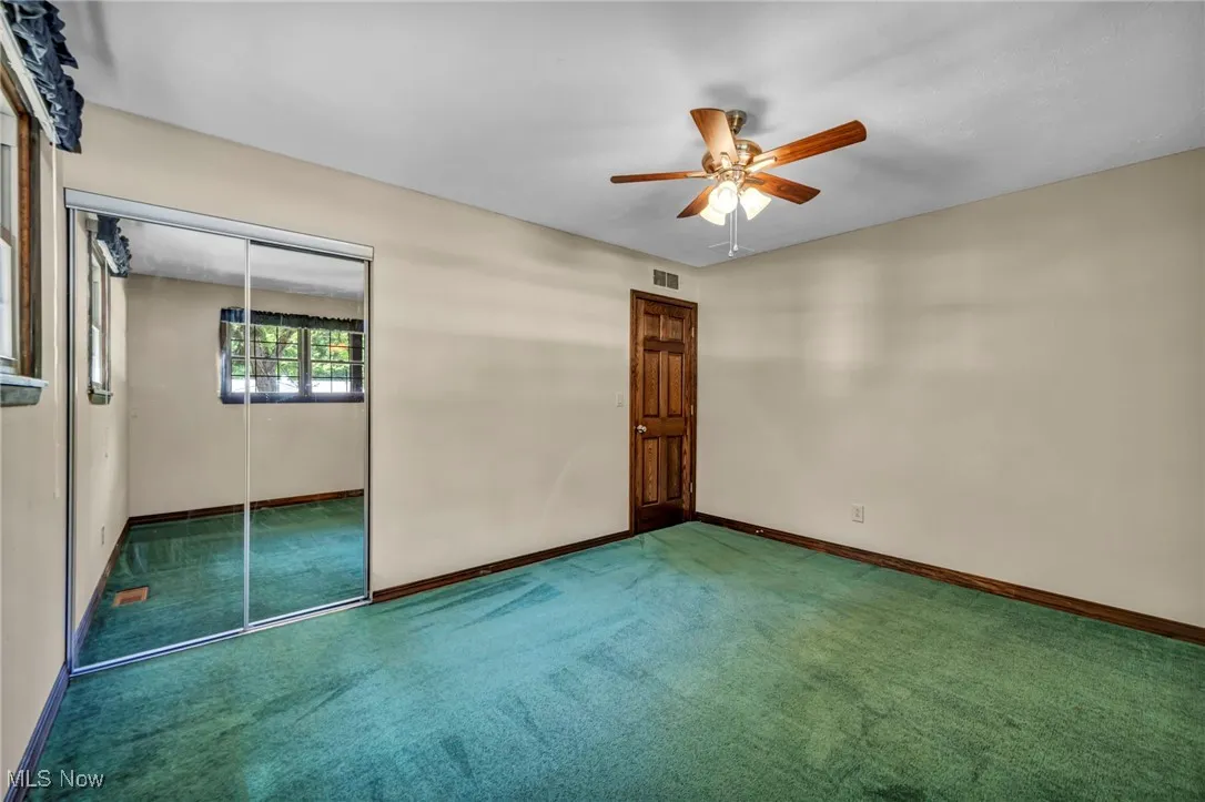 Unfurnished bedroom with carpet flooring, a closet, and ceiling fan