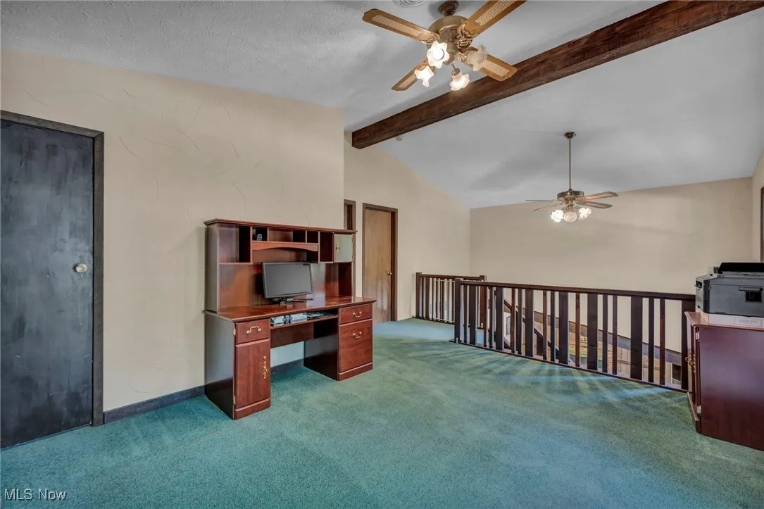 Unfurnished office featuring ceiling fan, carpet flooring, and a textured ceiling