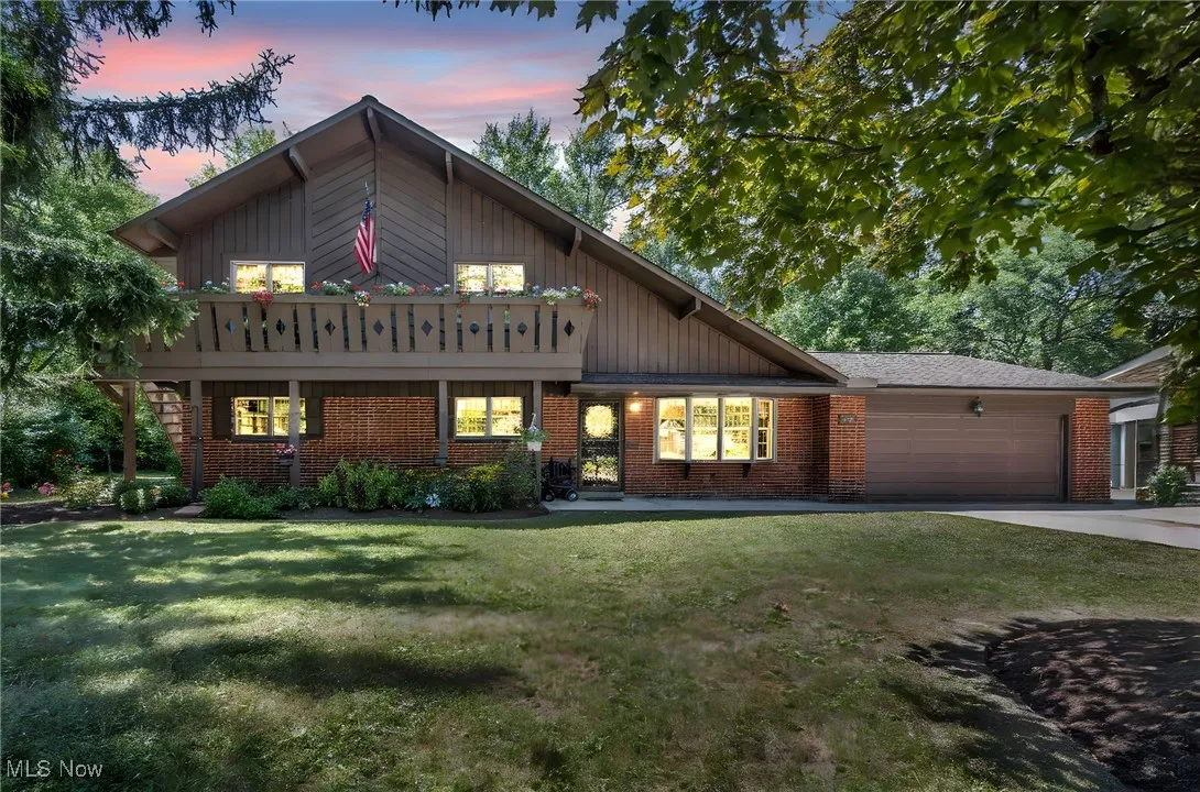View of front of property featuring an attached garage, driveway, a yard, and board and batten siding