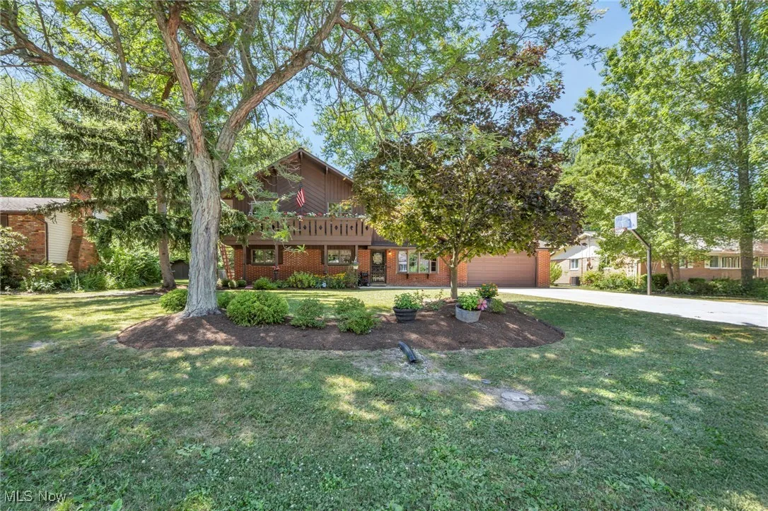 Mid-century inspired home with driveway, brick siding, and a front yard