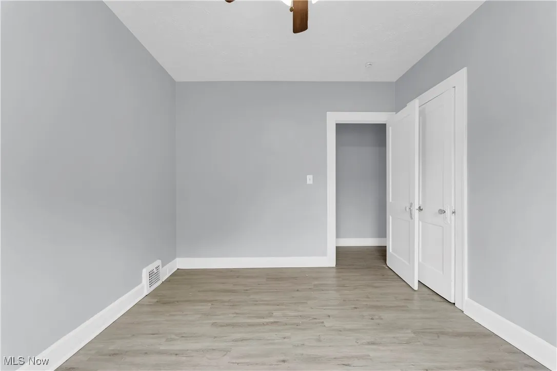 Unfurnished bedroom featuring wood finished floors, ceiling fan, and a closet