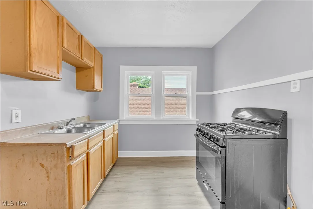 Kitchen featuring black gas stove, light countertops, and light wood-style floors