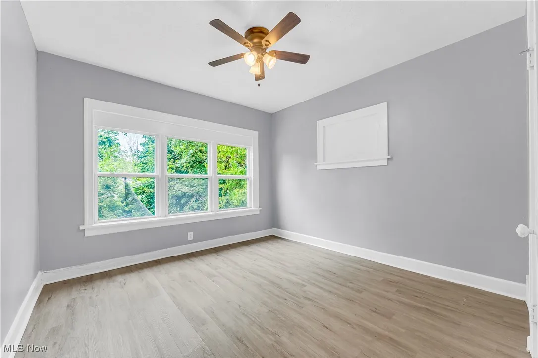 Empty room with wood finished floors and ceiling fan