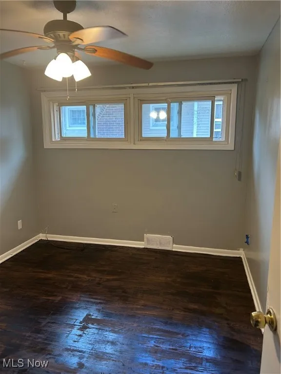Spare room with hardwood / wood-style flooring and ceiling fan