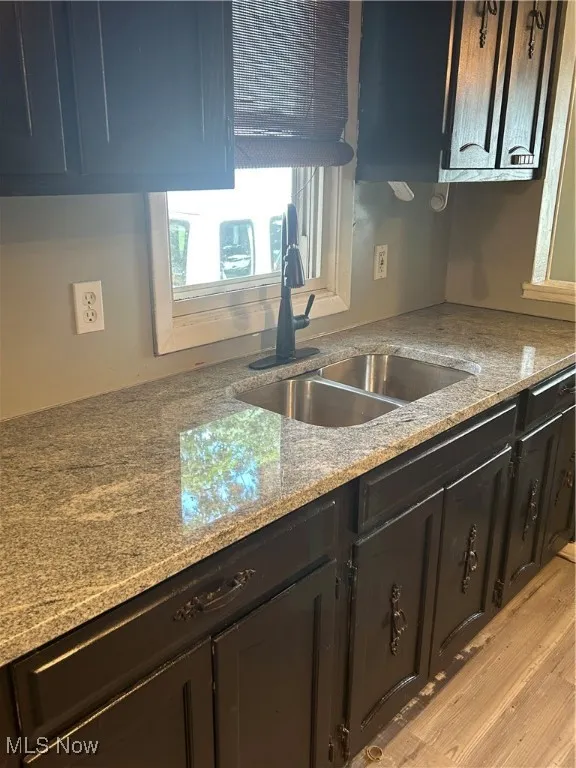 Kitchen with light stone countertops and light wood finished floors