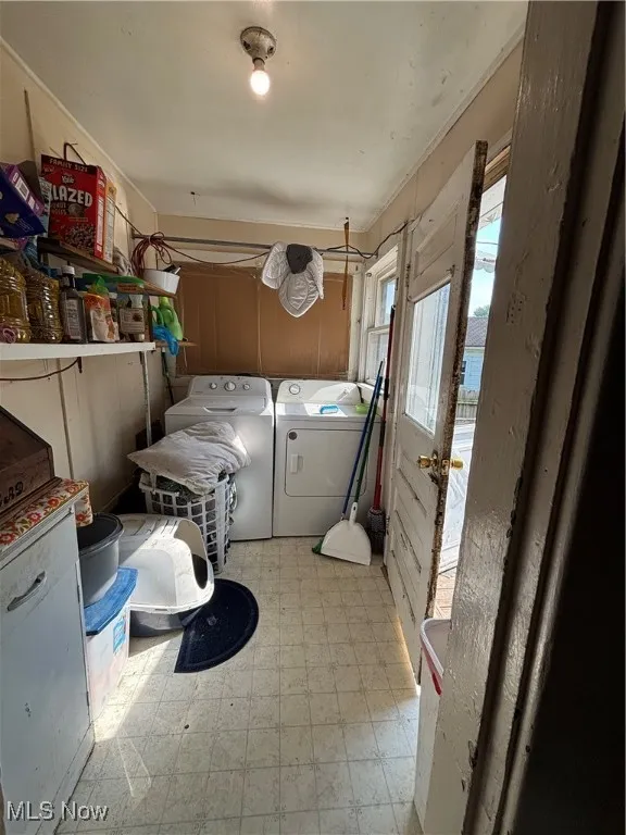 Laundry area with light flooring and separate washer and dryer