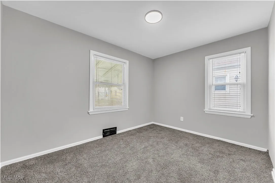 Empty room with carpet floors and baseboards