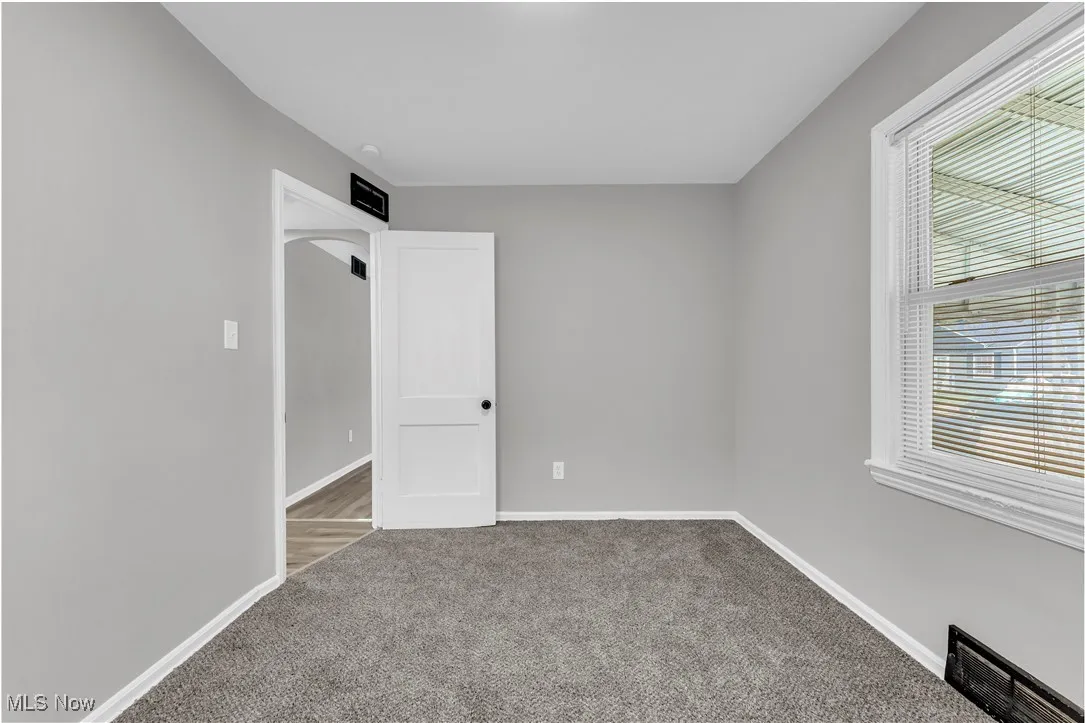 Empty room featuring carpet and baseboards