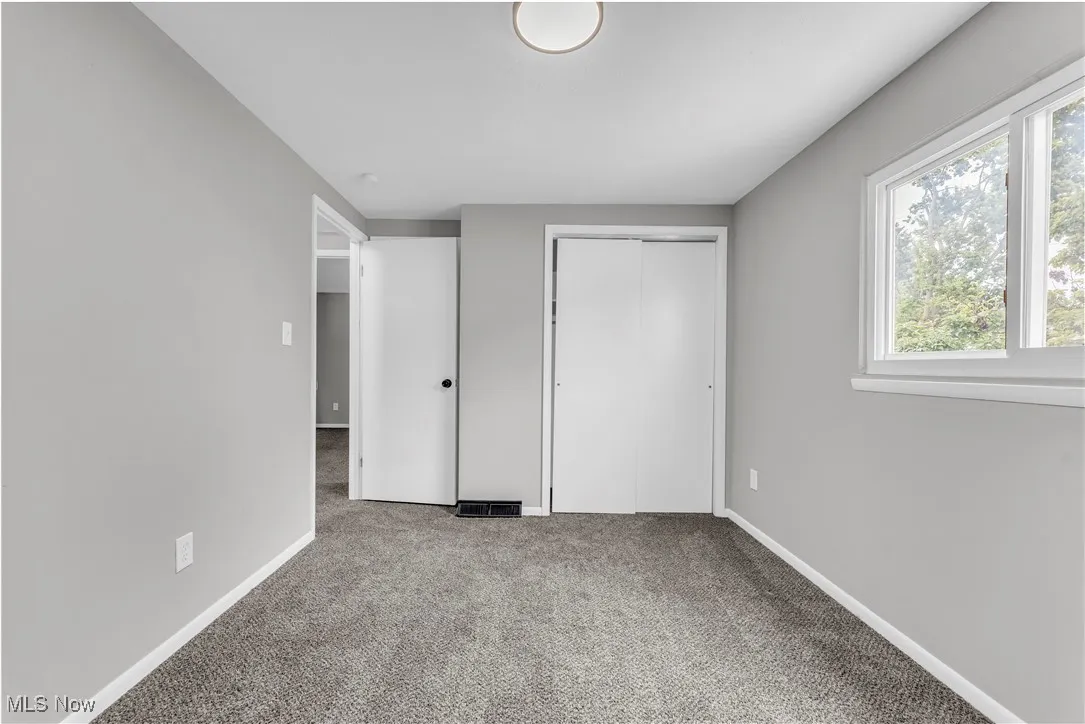 Unfurnished bedroom with a closet and carpet