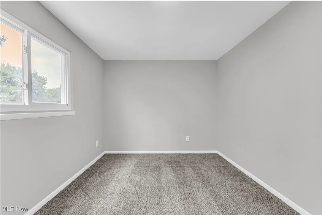 Empty room with carpet floors and baseboards
