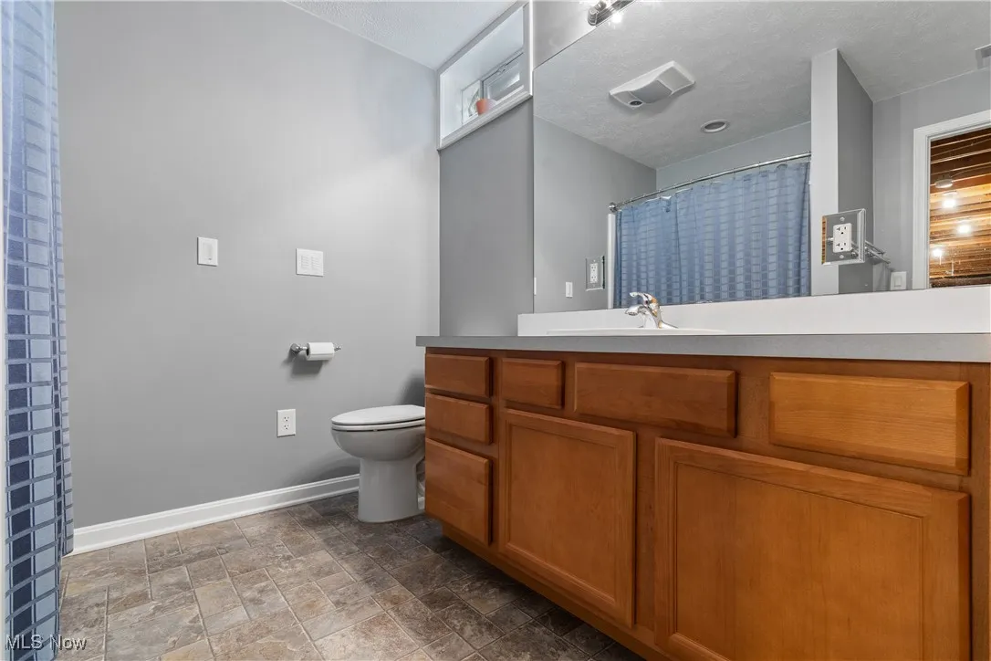 Full bathroom with vanity and stone finish flooring