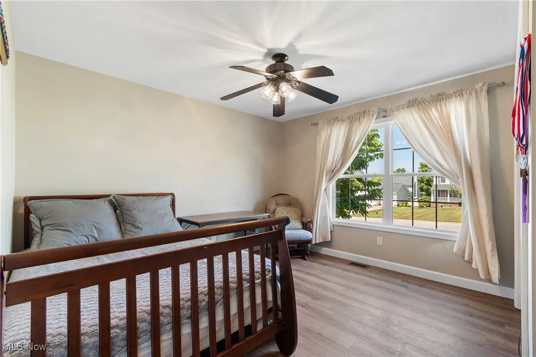 Bedroom with light wood-style flooring and a ceiling fan