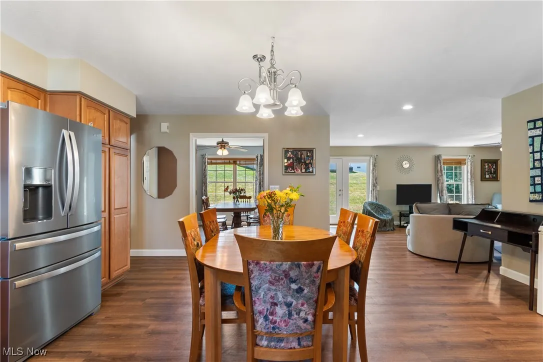 Dining room with dark wood finished floors, recessed lighting, a chandelier, and a ceiling fan