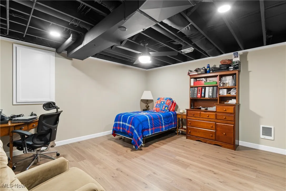 Bedroom featuring light wood-style flooring and an office area