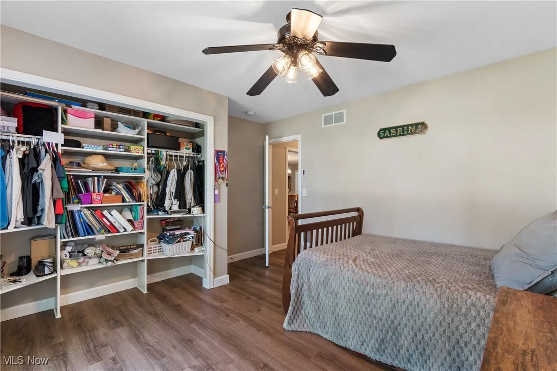 Bedroom with wood finished floors, ceiling fan, and a closet