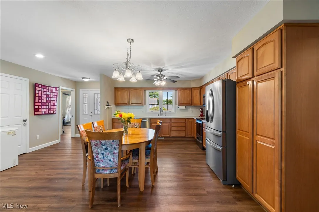 Kitchen featuring appliances with stainless steel finishes, recessed lighting, dark wood finished floors, light countertops, and brown cabinets