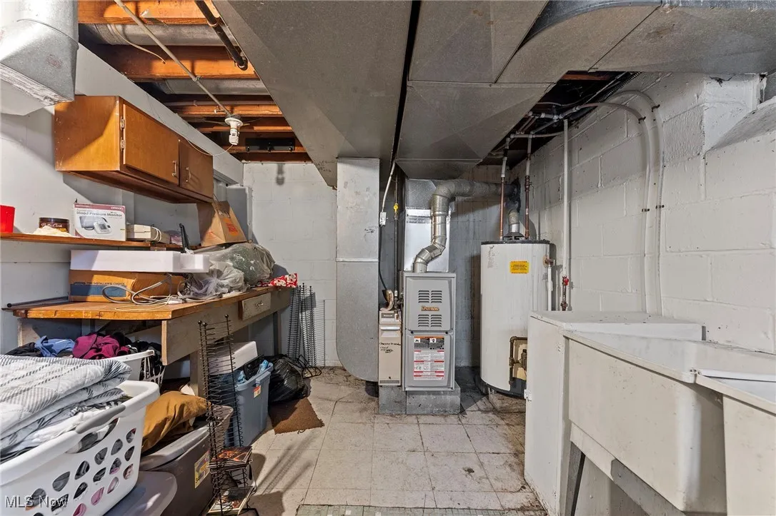 Unfinished below grade area with heating unit and water heater
