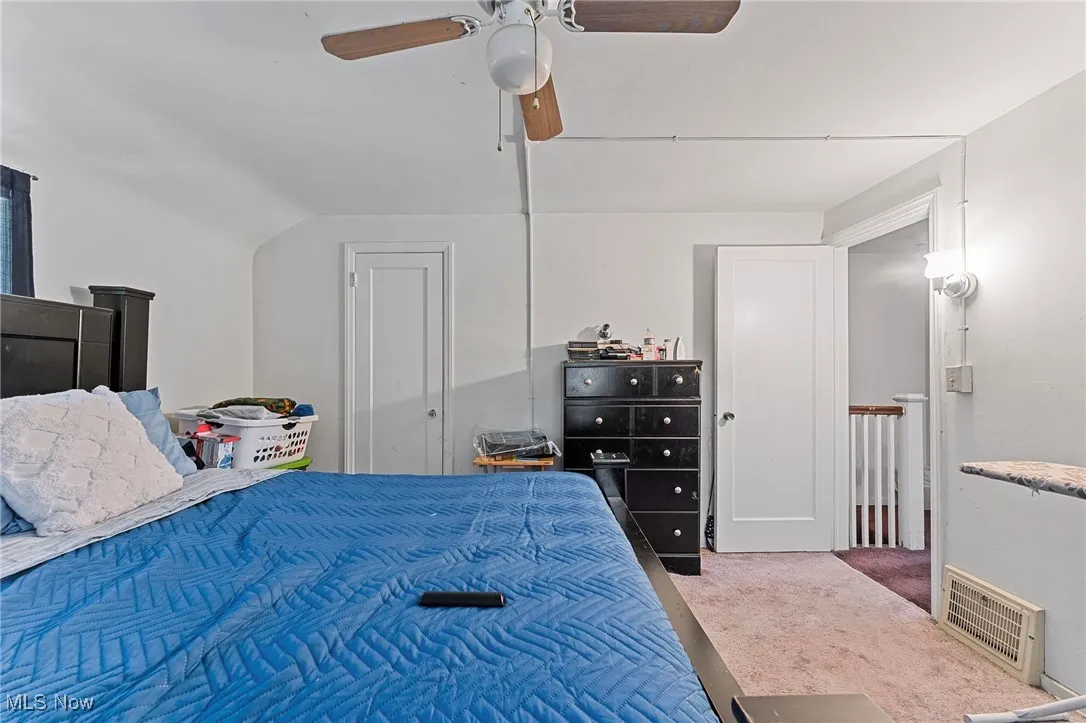 Carpeted bedroom featuring a ceiling fan