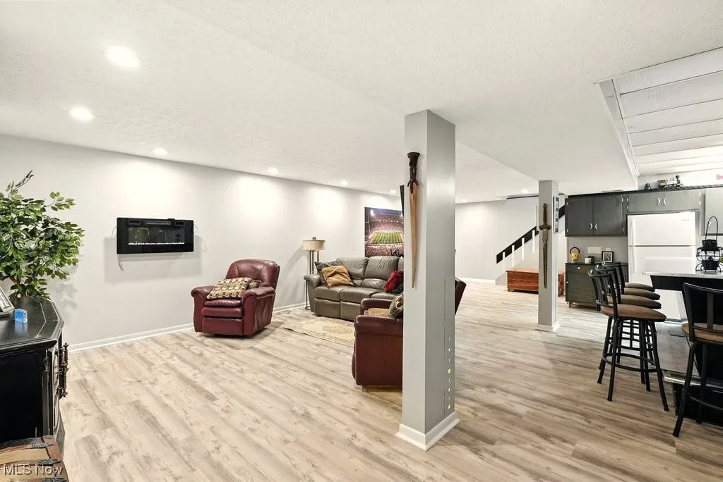 Living room with light wood-style floors, stairway, recessed lighting, and a textured ceiling