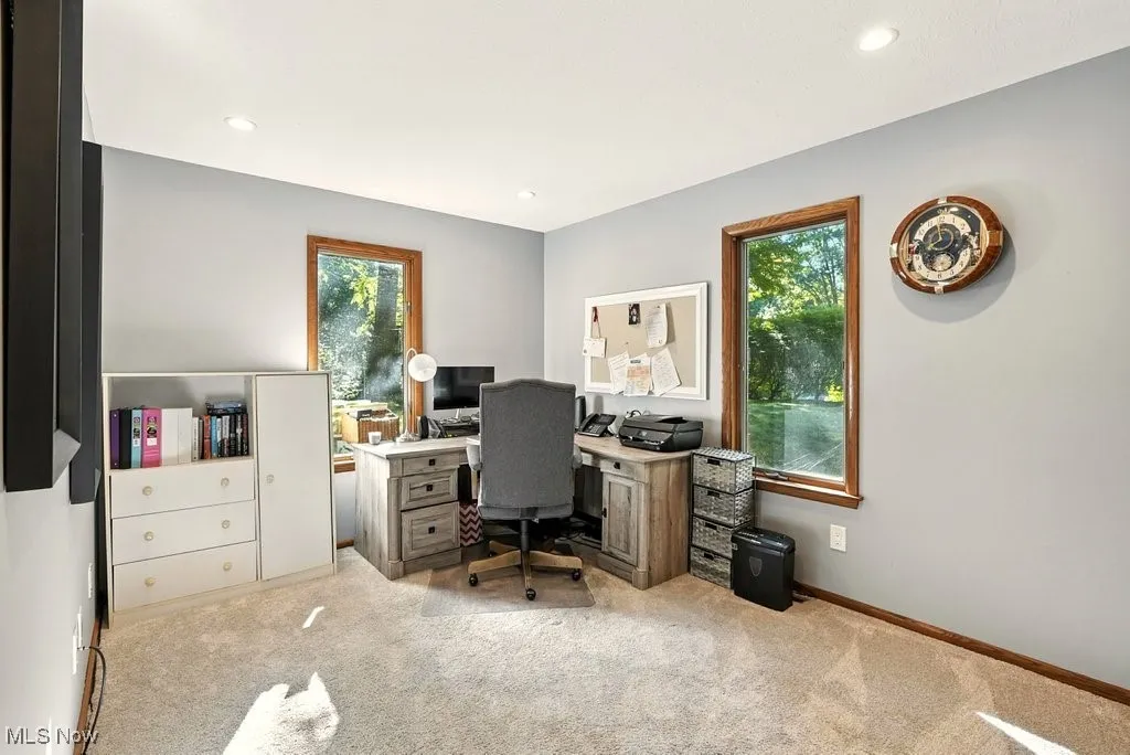 Office space with light carpet and recessed lighting