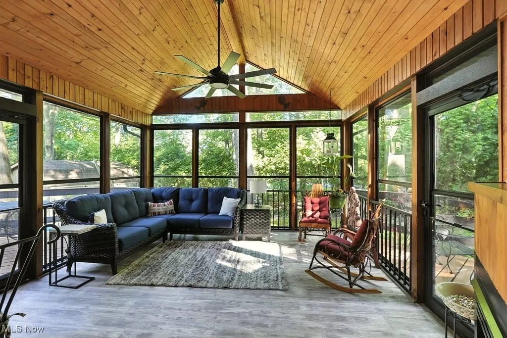 Sunroom / solarium featuring healthy amount of natural light, a ceiling fan, and an outdoor hangout area